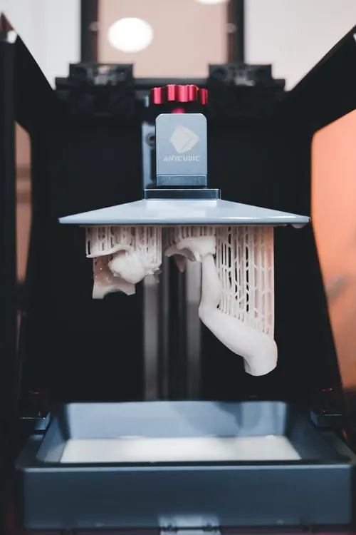 Piezas blancas de impresión 3D en resina suspendidas con estructuras de soporte
